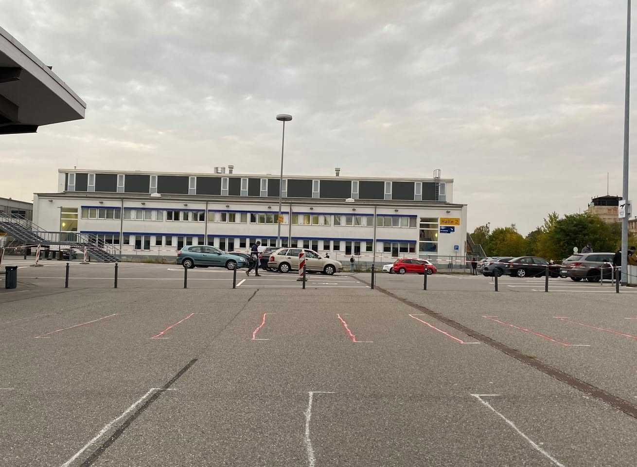 Menschen werden auf dem Parkplatz in verschiedenfarbige Bereiche eingeteilt,